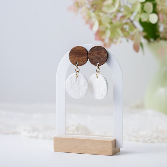 Balti auskari ar ziedu motīvu